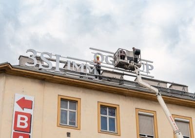 Werbeschildmontage über den Dächern von Wien